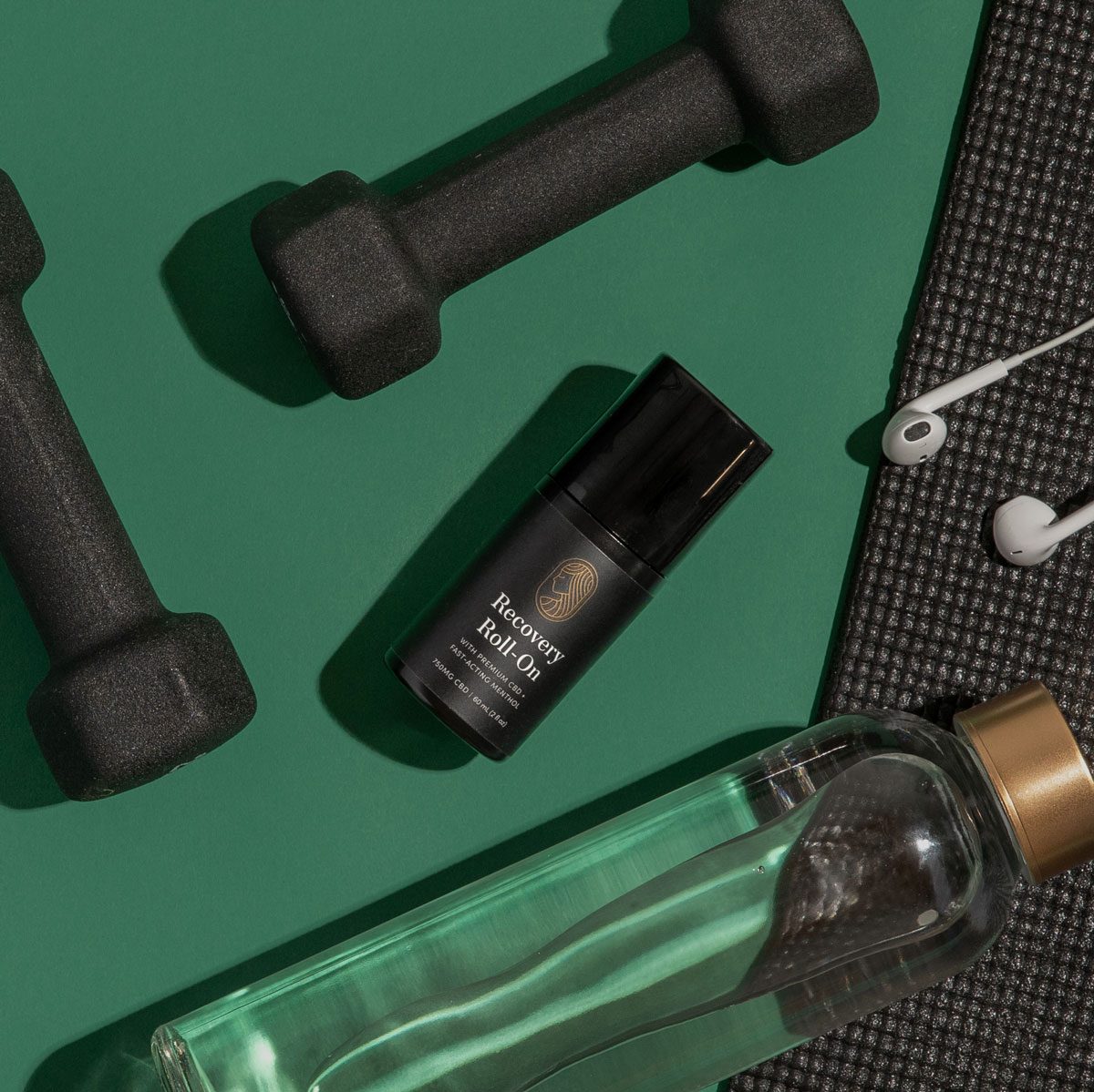 Green backgound image showing Recovery Roll-On, handweights, earbuds, a yogamat, and water bottle.