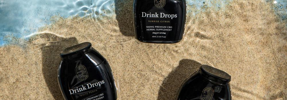 CBD Drink Drops in water hand Summer Mocktails