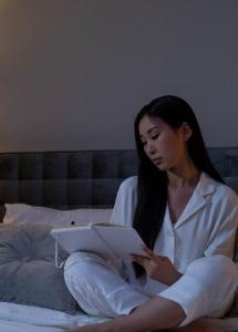 woman in bed writing in journal